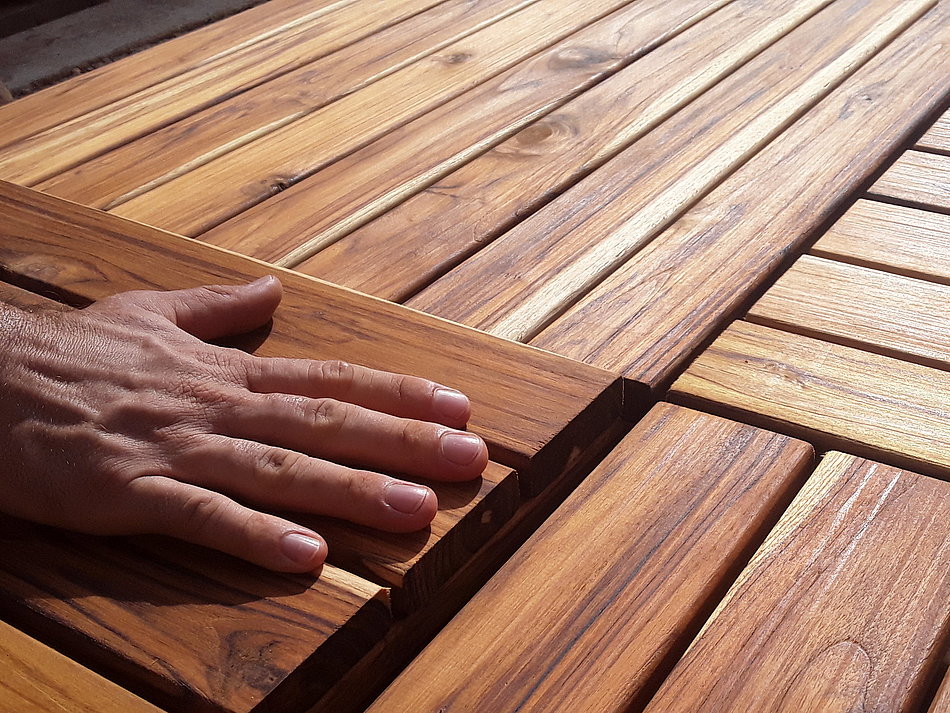 Eine Hand streicht über Holzplatten